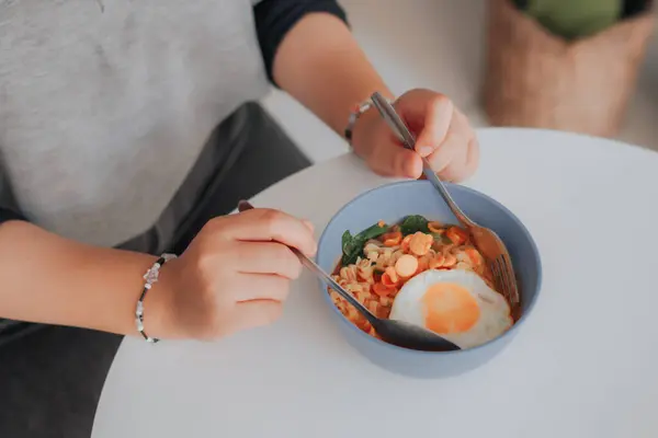Asyalı kadın pirinç eriştesi yiyor.