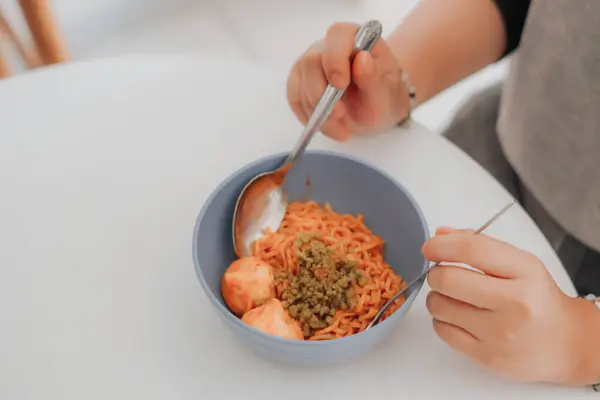 Masada spagetti yiyen kadın.