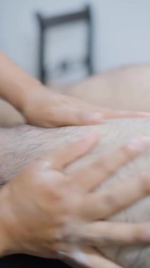 Manos femeninas masajeando una pierna masmanina durante una sesde fisioterapia