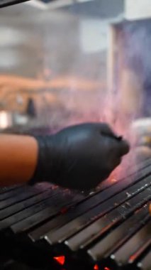 Hamburgeri ateşe vermek için pişirme aletiyle yağlanıyor.