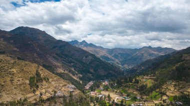 Güney Amerika dağlık dağlık bölgede bitki örtüsü ve bulutlu bir günde arka planda bazı binalar