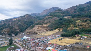 Peru 'daki dağların arasına yerleşmiş bir And kasabasının panoramik hava manzarası geleneksel evleri, renkli çatıları ve doğal manzaraları gözler önüne seriyor.