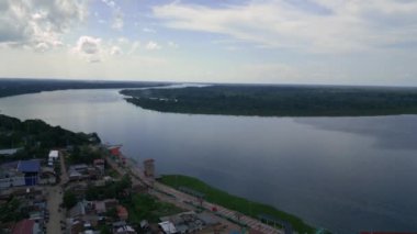 Amazon nehrinin havadan çekilmiş fotoğrafı. Yanında bir şehir var.