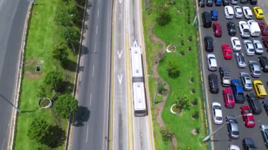 Lima, Peru 'nun göbeğinde güneşli bir günde canlı bir şehir meydanının altından geçen bir otobüs