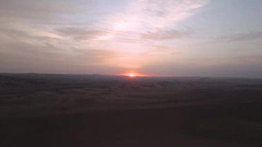 Peru 'daki Ica' nın sakin çölünün üzerinde gün batımının sinematik drone çekimi