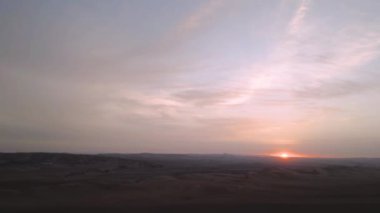 Peru 'daki kurak Ica çölünde günbatımı insansız hava aracı uçuşu geniş bir ufka sahip.