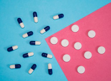 Açık mavi arkaplana yayılmış çeşitli haplar..