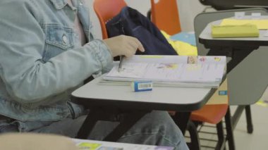 Sınıfta iki genç kız dil kitaplarını açıyor, derslerine başlamaya hazırlar..