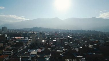 Huancayo şehrinin panoramik drone görüntüsü ön planda tarihi kilise, güneşli bir sabah.