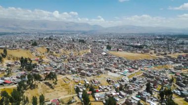 Huancayo 'nun panoramik hava manzarası ve Andean platosunu çevreleyen canlı mavi gökyüzü.