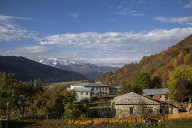 Güz cazibesiyle görkemli dağlara karşı sergilenen sakin bir köyü gösteren güzel ve pitoresk bir manzara. Georgia 'nın kuzeyinde yer alan gizemli Svaneti' nin güzel manzaraları.