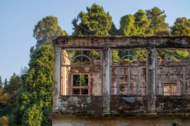 Etrafı bereketli ağaçlar ve yeşilliklerle çevrili çok sayıda büyük penceresi olan antik ve büyüleyici bir bina.