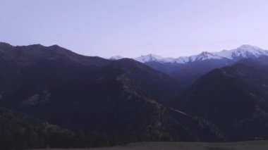 Berrak bir alacakaranlık altında sakin bir dağ manzarası yaşayın. Güzellik ve dinginlik sergiliyor.