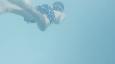 Suyun altında zarif bir şekilde yüzen bir insan, akışkan su hareketinin ve yeteneğinin büyüleyici güzelliğini sergiliyor.