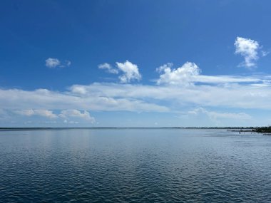 Dalgalar, Florida Keys 'in okyanus sularını sular bulutlar ufukta mavi bir gökyüzü gibi süzülür.