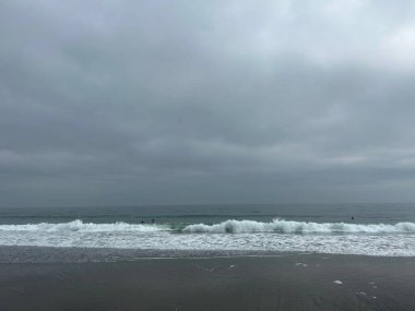 Bir açık deniz fırtınası New England kıyılarına etkileyici dalgalar getiriyor. Dalgaların tadını çıkaran sörfçülerin yanında minyatür kalıyor.