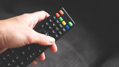 Uzaktan kumandalı bir el, siyah düğmeli televizyon fotoğrafı.