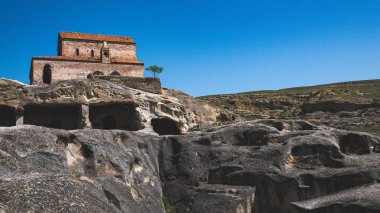 Views of uplistsikhe ancient rock town in country of Georgia stone walls travel clipart