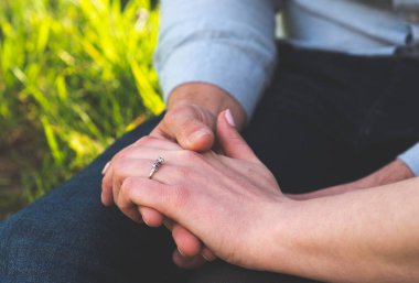 Erkek ve kadın el ele tutuşuyor. Nişan yakın ilişkiler.