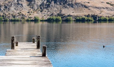 Sudaki ahşap iskele köprüsü. Yeni Zelanda 'daki temiz göl. Yeni Zelanda yatay.