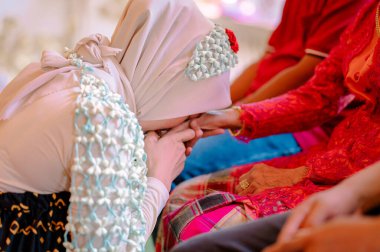 Gelin ve damat gelinlik giyiyorlar.