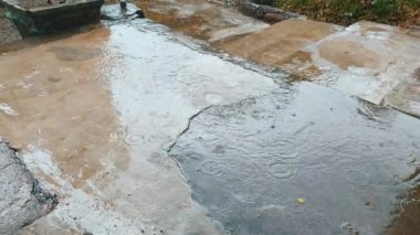 Yağmur damlaları beton yüzeyde su birikintileri oluşturur