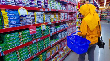 Pinrang-Makassar, Endonezya, 28 Ekim 2024: Asyalı kadınlar Matahari süpermarketinde kentsel yaşam tarzı alışverişinden hoşlanıyorlar. Süpermarket sepetleri tutan güzel kadınlar alışveriş merkezinde süpermarket rafları taşırken yiyecek seçiyor ve satın alıyorlar..