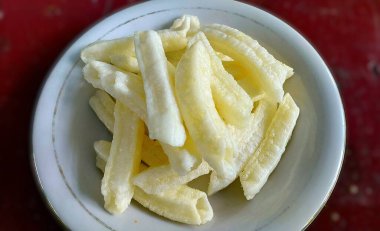 Endonezya dilinde Kerupuk panjang, tipik bir Endonezya yemeği veya baharatı. Kızarmış tapyoka unu uzun ve ince bir şekilde. Beyaz bir plaka üzerinde, bulanık bir arkaplanda izole edilmiş.