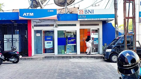 Parepare-Makassar, Endonezya, Kasım 09, 2024: Para çekmek veya hesabını kontrol etmek için BNI ve BRI Otomatik Teller Machine 'e (ATM) giren kimliği belirsiz bir kadının portresi.