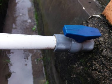 Su ya da drenaj bölgesinde mavi valfli beyaz PVC boru. su borusu