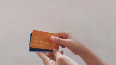 Bir adamın altı renkli kredi kartı vardır. Kartlar kestane rengi, turuncu, yeşil, mavi, beyaz ve siyah..