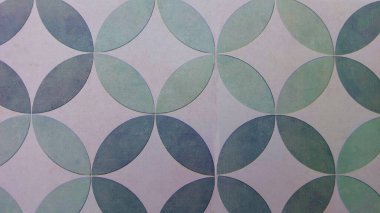 Üst üste binen dairesel geometrik desenlerle zeminin görsel soyut dokusu tekrarlayan ve dinamik bir izlenim yaratır. Yüzey yumuşak yeşil ve mavi renk varyasyonlarıyla pürüzsüz görünüyor.
