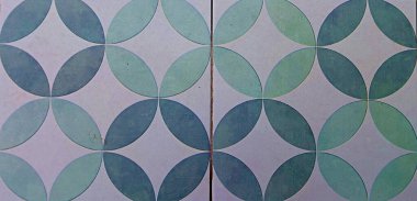 Üst üste binen dairesel geometrik desenlerle zeminin görsel soyut dokusu tekrarlayan ve dinamik bir izlenim yaratır. Yüzey yumuşak yeşil ve mavi renk varyasyonlarıyla pürüzsüz görünüyor.