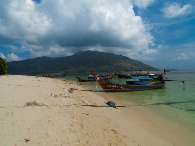 Wonderful tropical beach in Koh Lipe Thailand with long tail boat anchored clipart