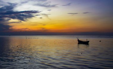 BOAT IN THE MIDDLE OF THE SEA WHEN SUNSET clipart