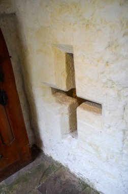 Kilisenin duvarındaki tahta haçın dikey görüntüsü.