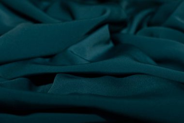 Bir desenli yeşil kumaş parçası. Kumaş katlanmış ve parlak bir görünüme sahip. Kumaş sentetik bir materyalden yapılmıştır. Sancak, arkaplan veya 3D haritalama için doku için arka plan