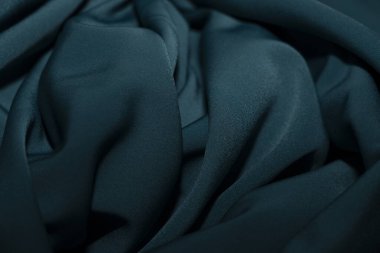 Bir desenli yeşil kumaş parçası. Kumaş katlanmış ve parlak bir görünüme sahip. Kumaş sentetik bir materyalden yapılmıştır. Sancak, arkaplan veya 3D haritalama için doku için arka plan