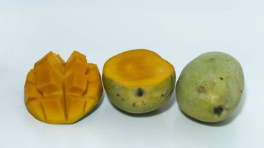 Beyaz arka planda yeşil mango ve mango dilimleri