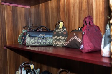 Geleneksel batik ve dokuma motifleriyle çeşitli kadın çantaları butikte sergileniyor
