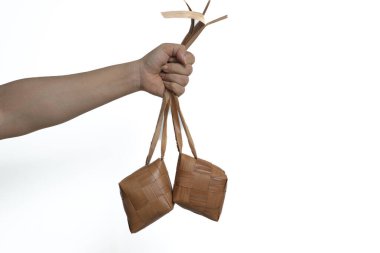 Beyaz arka planda el ele tutuşan ketupat ya da pirinç köftesi