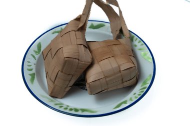 Beyaz arka planda bir tabakta ketupat ya da pirinç köftesi