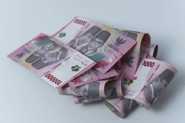 100.000 Rupiah Endonezya banknotları beyaz bir yüzeye yayıldı. Notlarda Soekarno ve Mohammad Hatta 'nın resimleri yer alıyor..