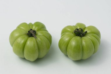 Beyaz zemin üzerinde taze yeşil gül domatesleri (Solanum lycopersicum)