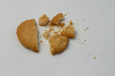 Kırık kurabiyeler beyaz arka planda izole edilmiş. Kurabiyeler kırıntılarla parçalanmış..