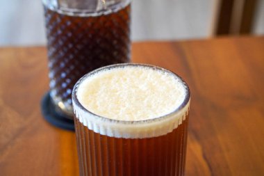 Black Peach Coffee, Endonezya, 16 Haziran 2025 'te ele geçirildi. Yumuşak bir karışım koyu sade kahve ve tatlı şeftali aromalı, meyveli ve aromatik bir karışımla soğuk servis edilir..