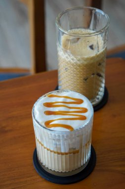 Buzlu Karamela Latte, Endonezya, 22 Haziran 2025 'te yakalandı. Süt ve tatlı karamelli şurupla harmanlanmış soğuk bir espresso, kremalı bir dokuma ve zengin karamel aroması sunuyor..