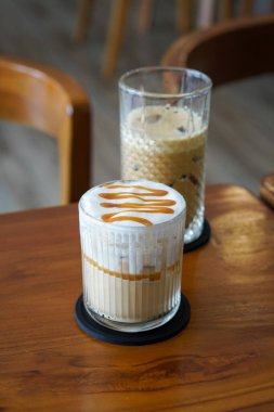 Buzlu Karamela Latte, Endonezya, 22 Haziran 2025 'te yakalandı. Süt ve tatlı karamelli şurupla harmanlanmış soğuk bir espresso, kremalı bir dokuma ve zengin karamel aroması sunuyor..
