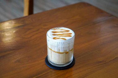 Buzlu Karamela Latte, Endonezya, 22 Haziran 2025 'te yakalandı. Süt ve tatlı karamelli şurupla harmanlanmış soğuk bir espresso, kremalı bir dokuma ve zengin karamel aroması sunuyor..