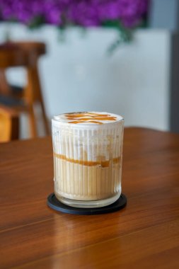 Buzlu Karamela Latte, Endonezya, 22 Haziran 2025 'te yakalandı. Süt ve tatlı karamelli şurupla harmanlanmış soğuk bir espresso, kremalı bir dokuma ve zengin karamel aroması sunuyor..
